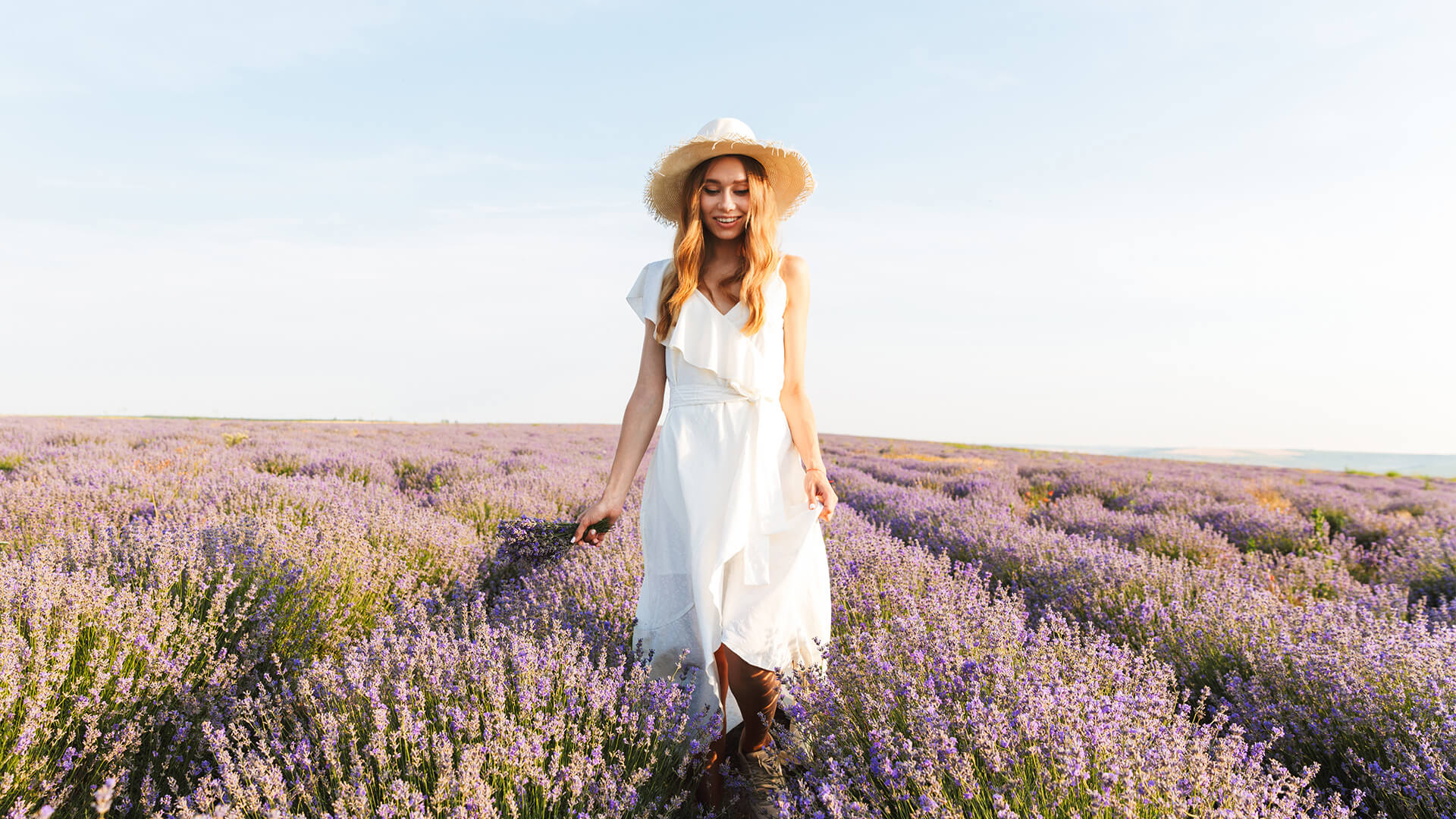 Woman in a white dress walking through a lavender field