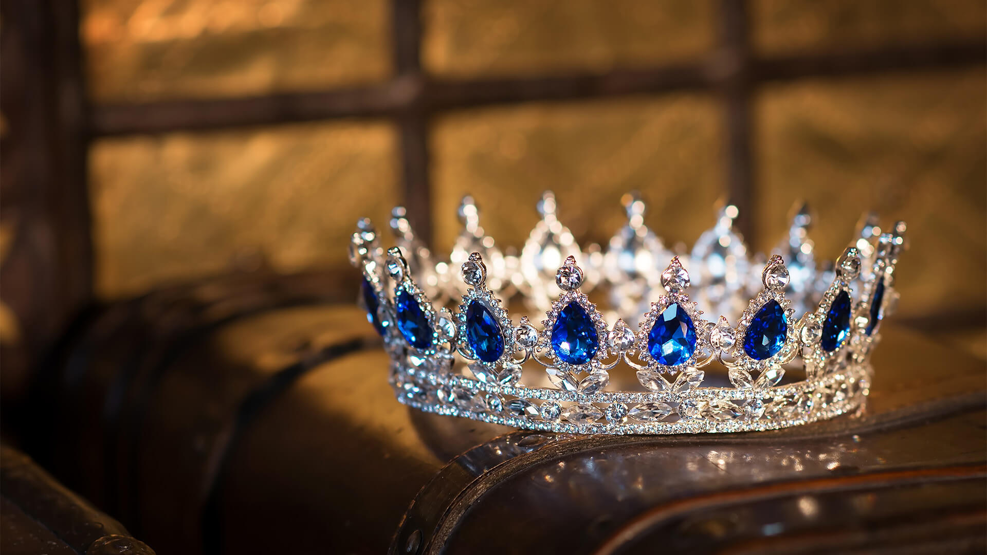 Sapphire and diamond crown resting on a brown leather surface