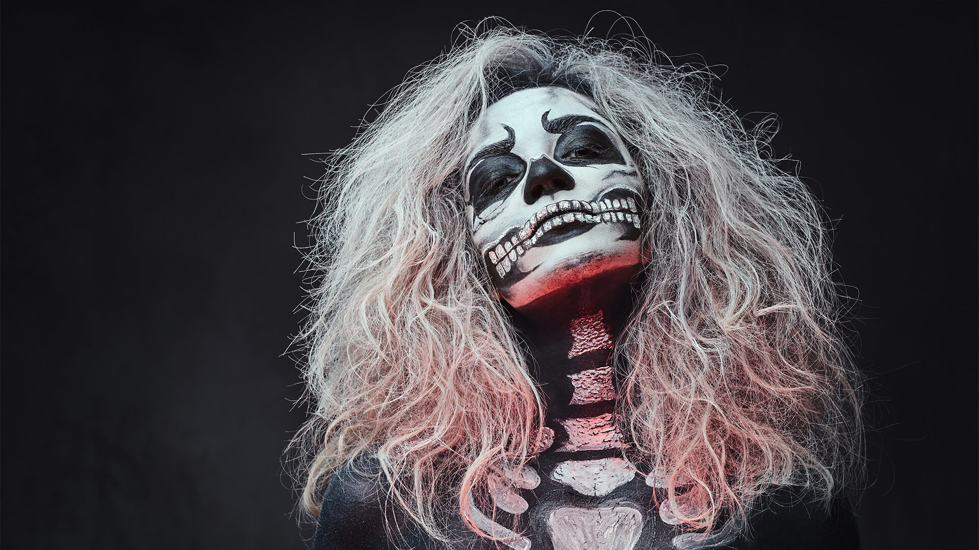 Woman in full body and face paint to look like a skeleton