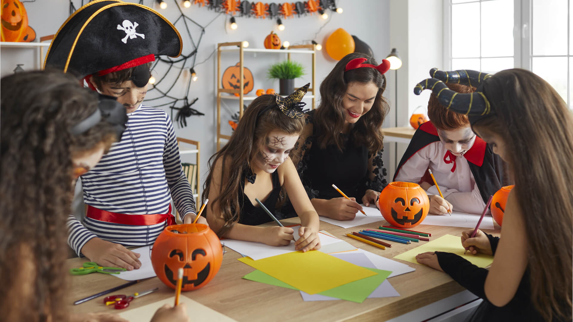 Kids and parent in fancy dress doing halloween crafts
