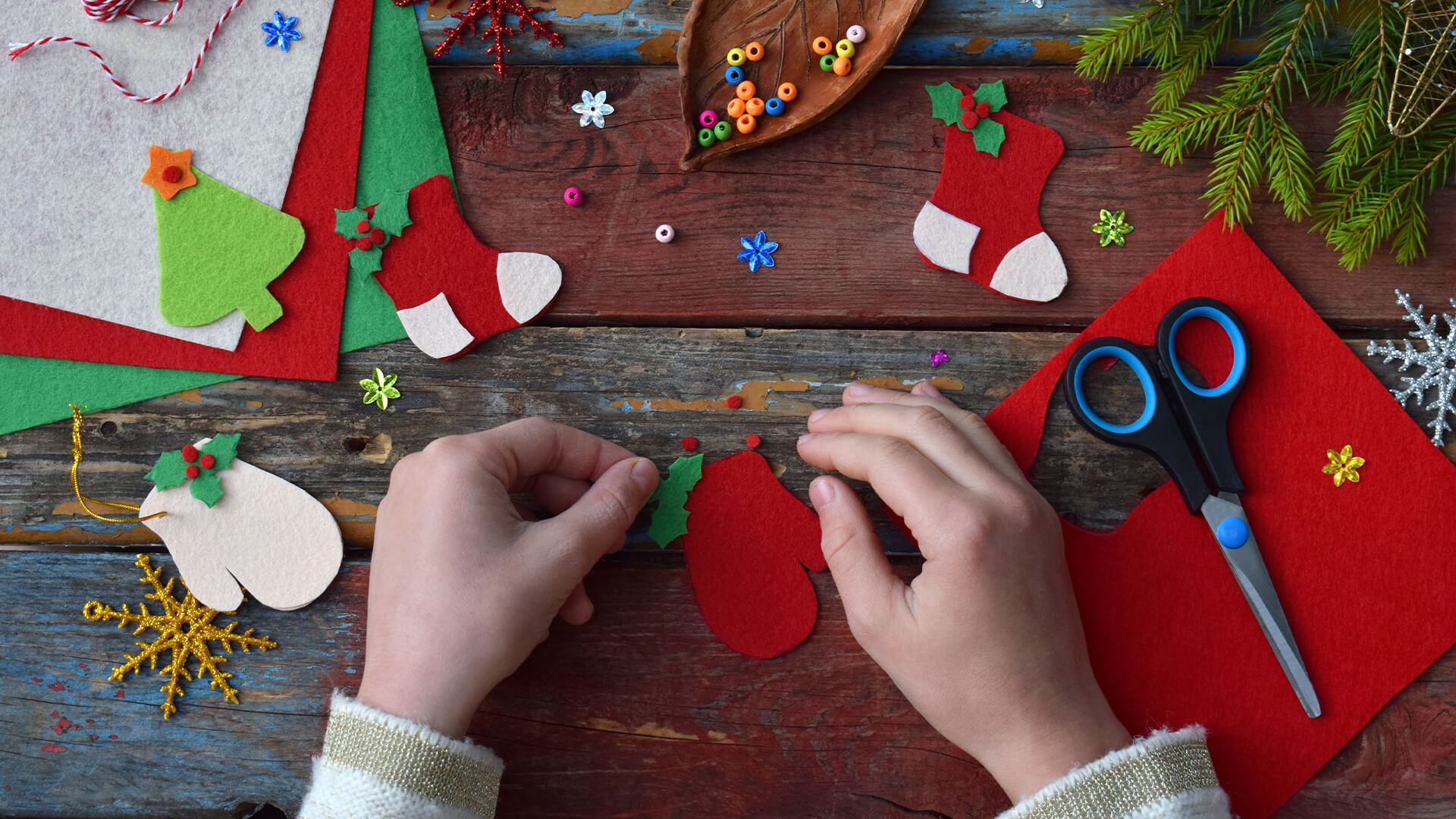 Table top view of a child creating felt christmas decorations