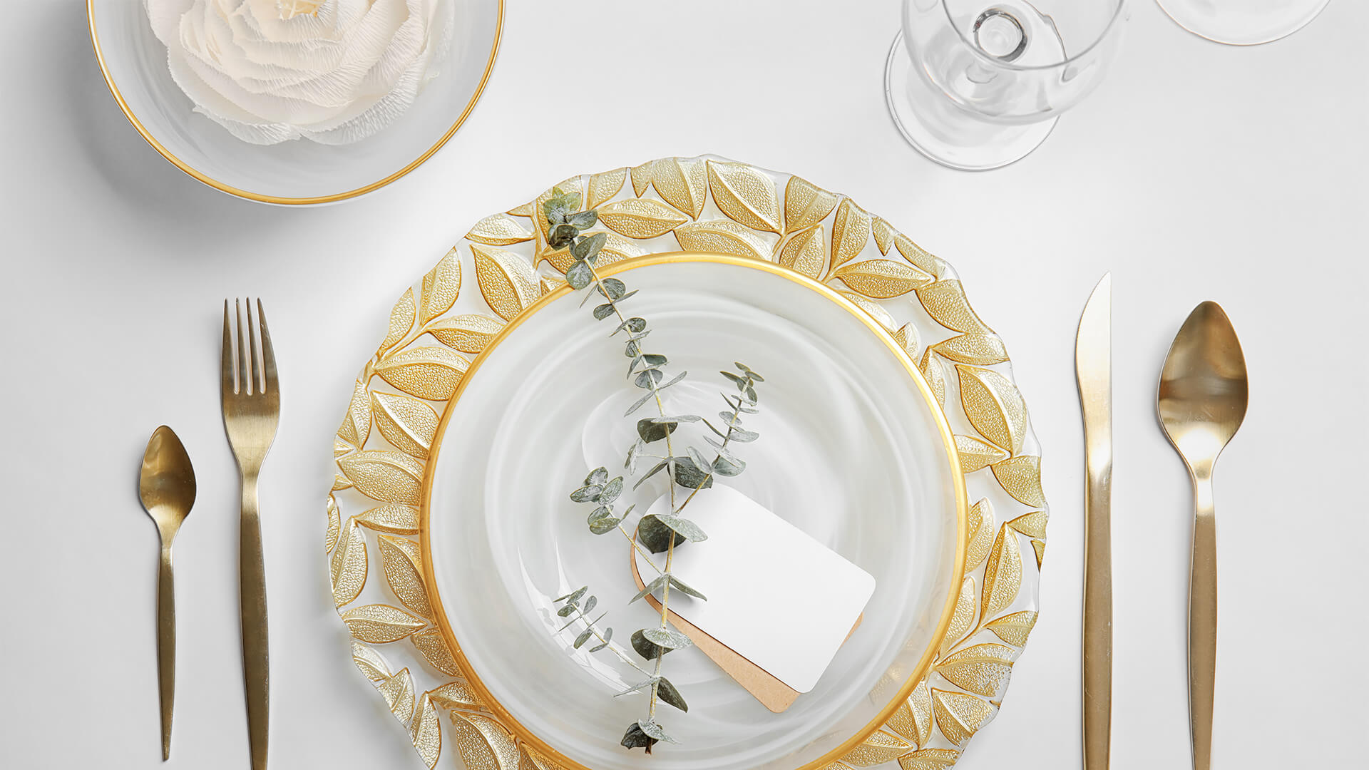 Luxury table setting with gold cutlery and white plates