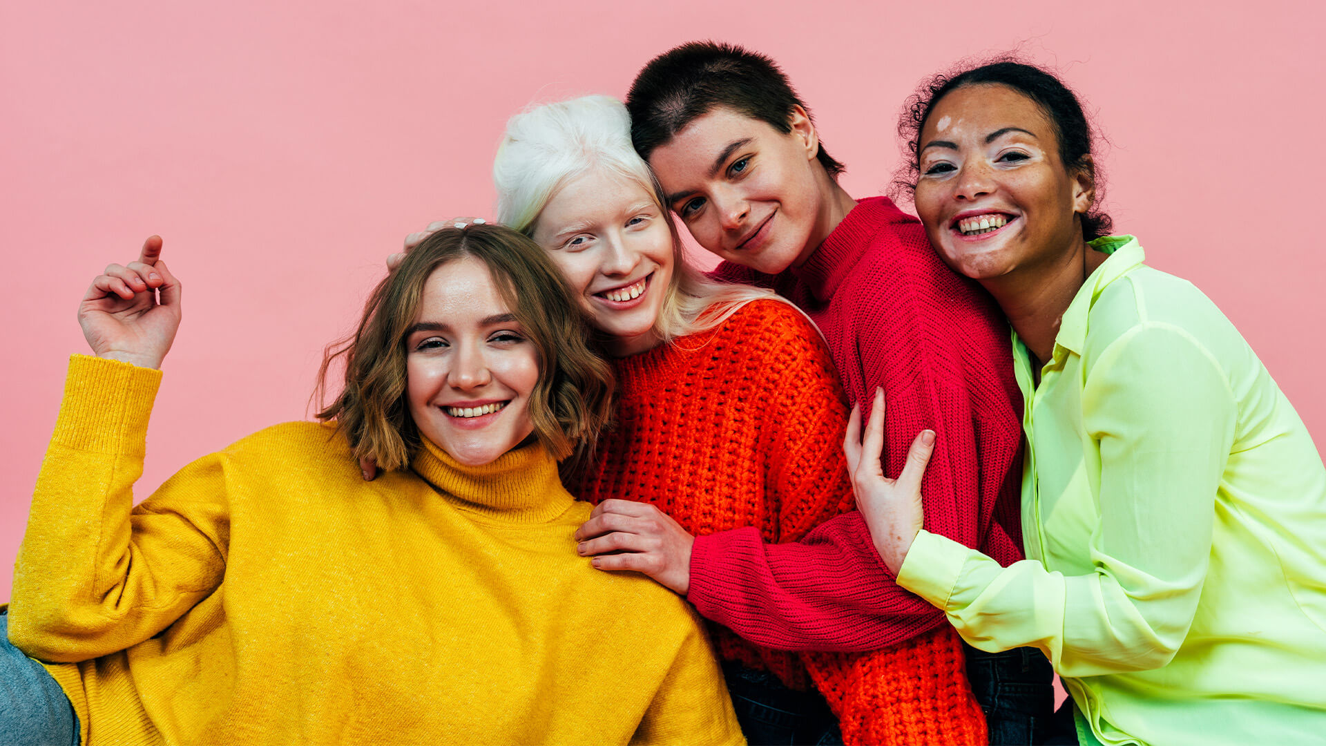 Four women with different body types and looks being happy together