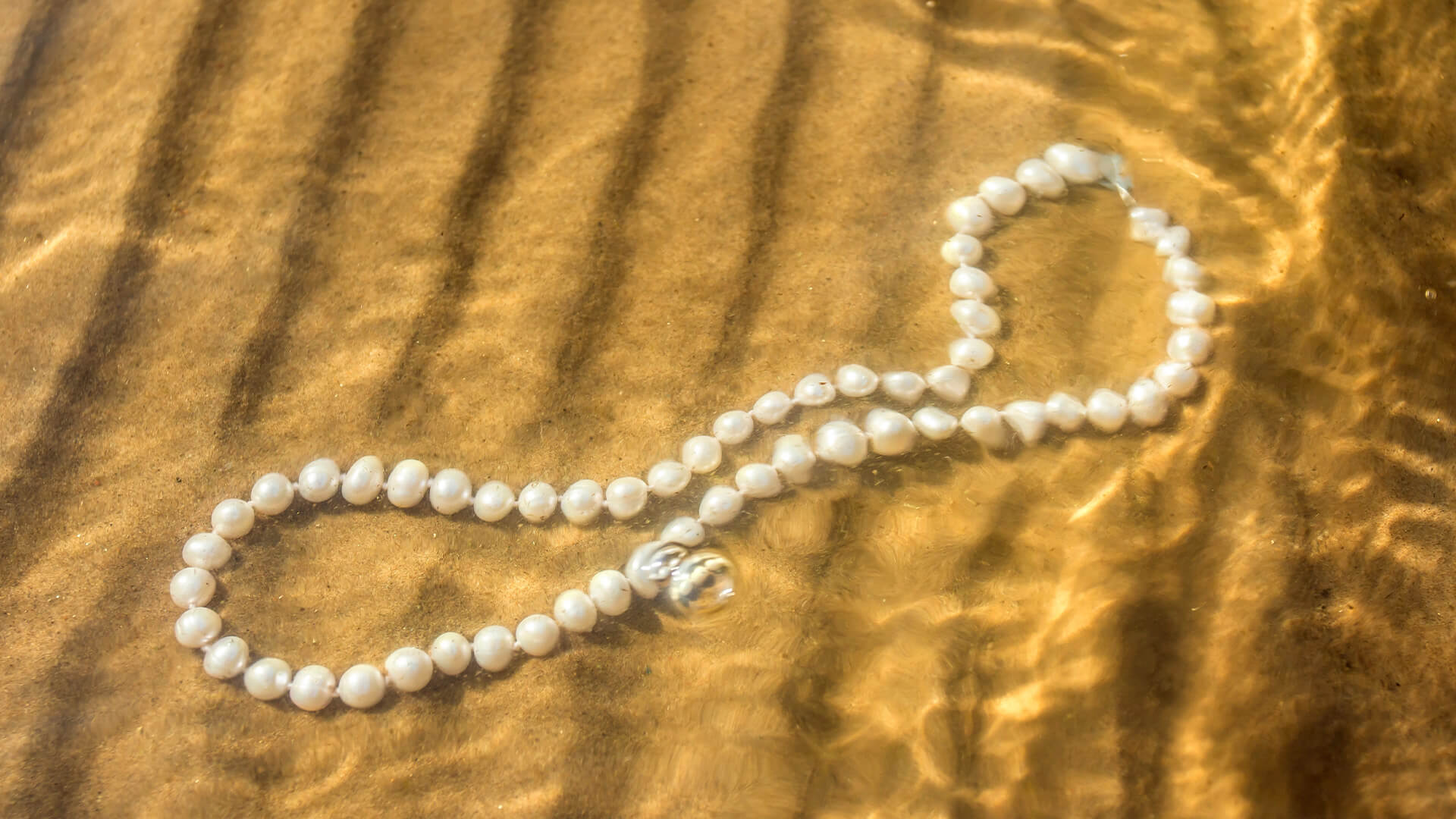 Pearl choker under water on the beach