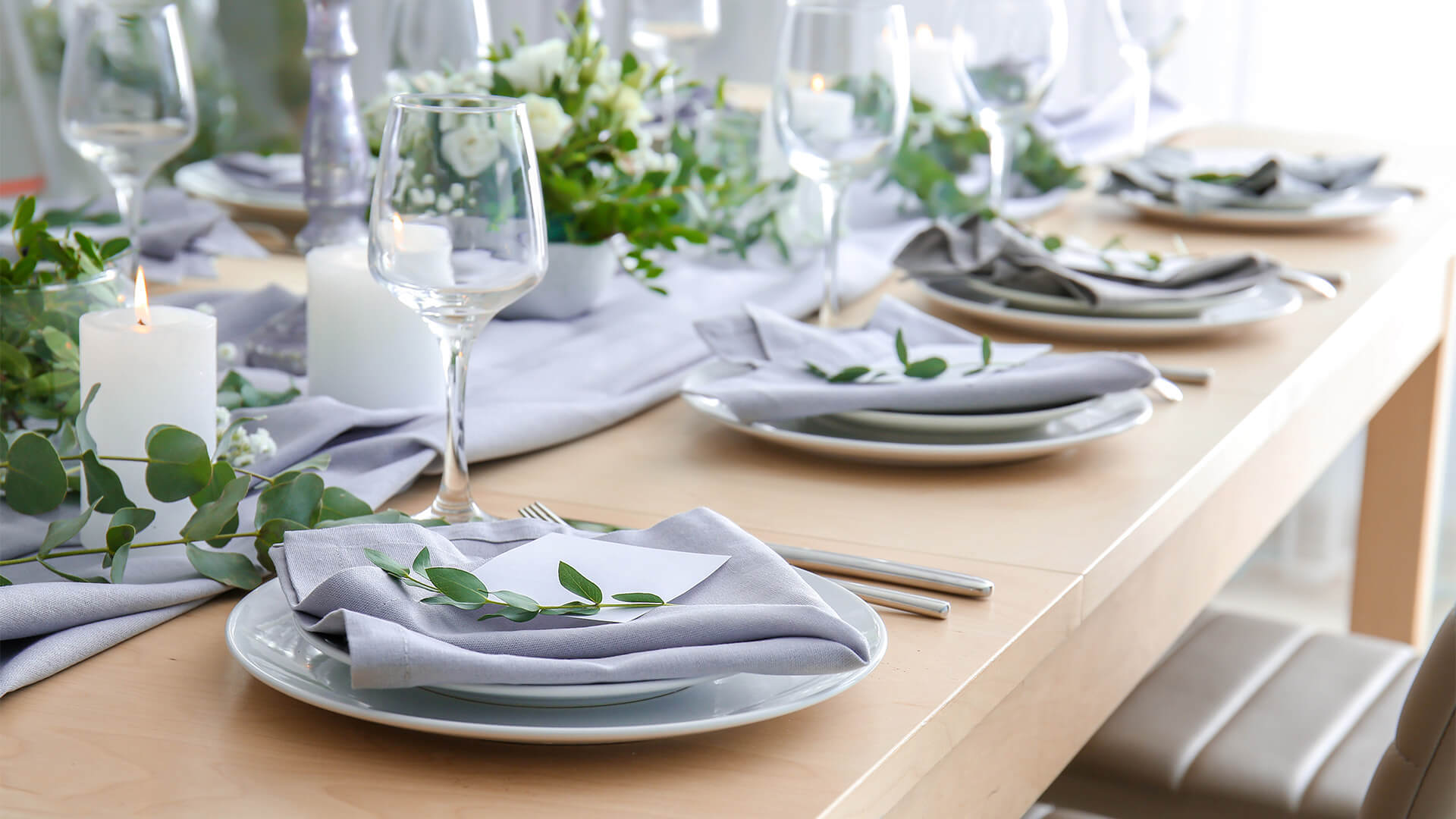 Wedding table setting with light blue decorations and green leaves