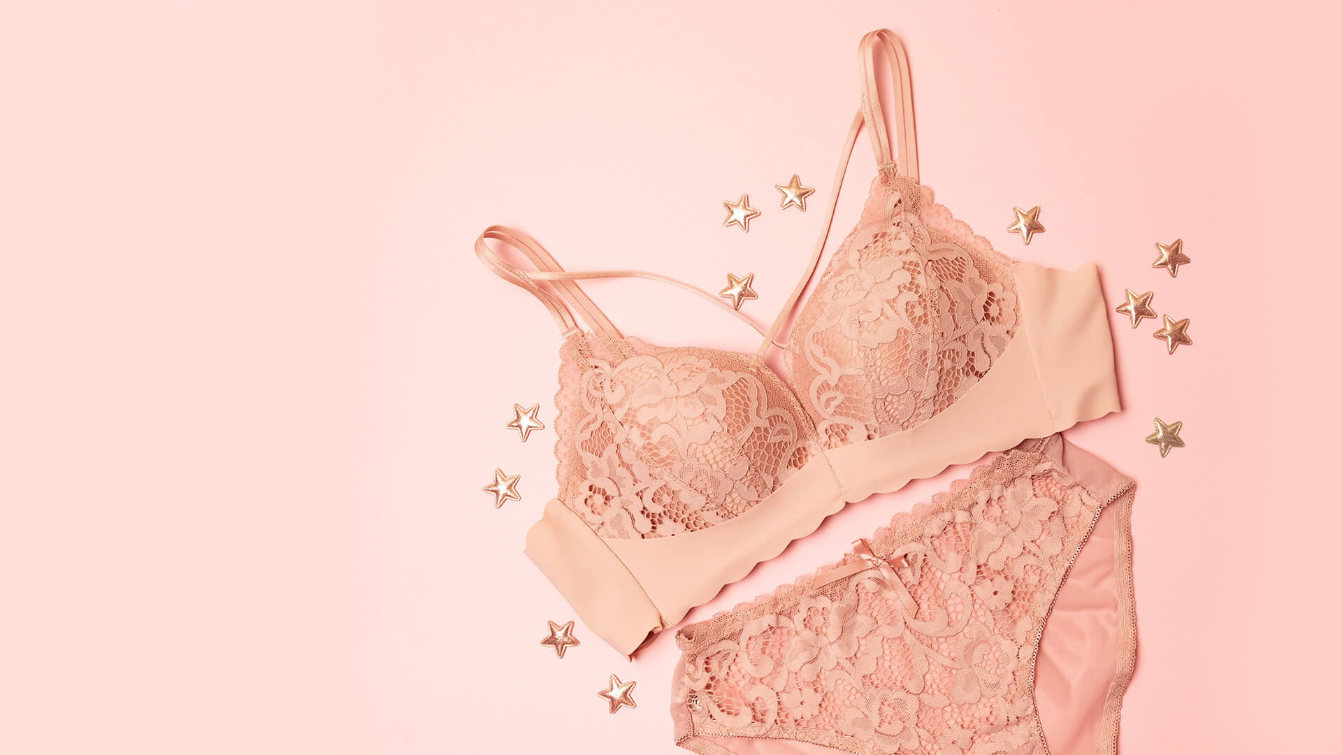 Pink lace bra and knicker set on a pink background
