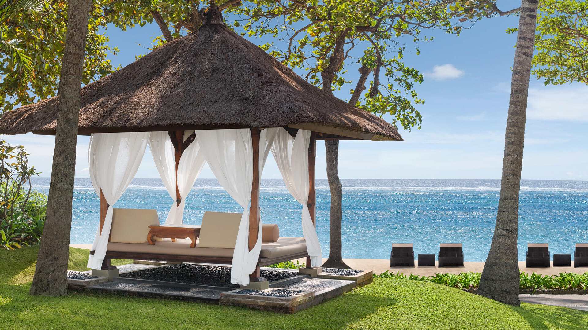 Gazebo with sun loungers on a beach in front of the ocean