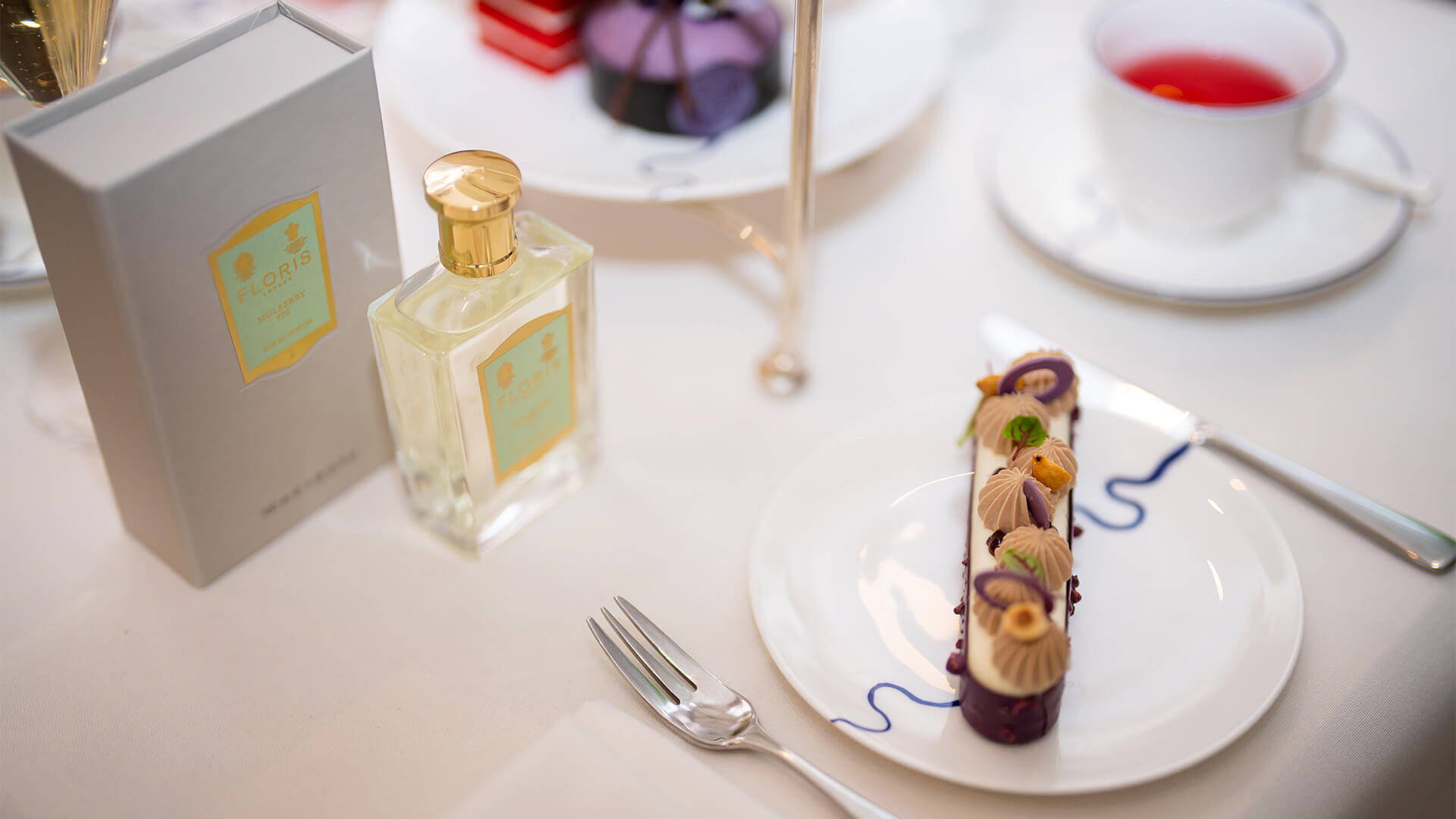 Dessert and perfume on table