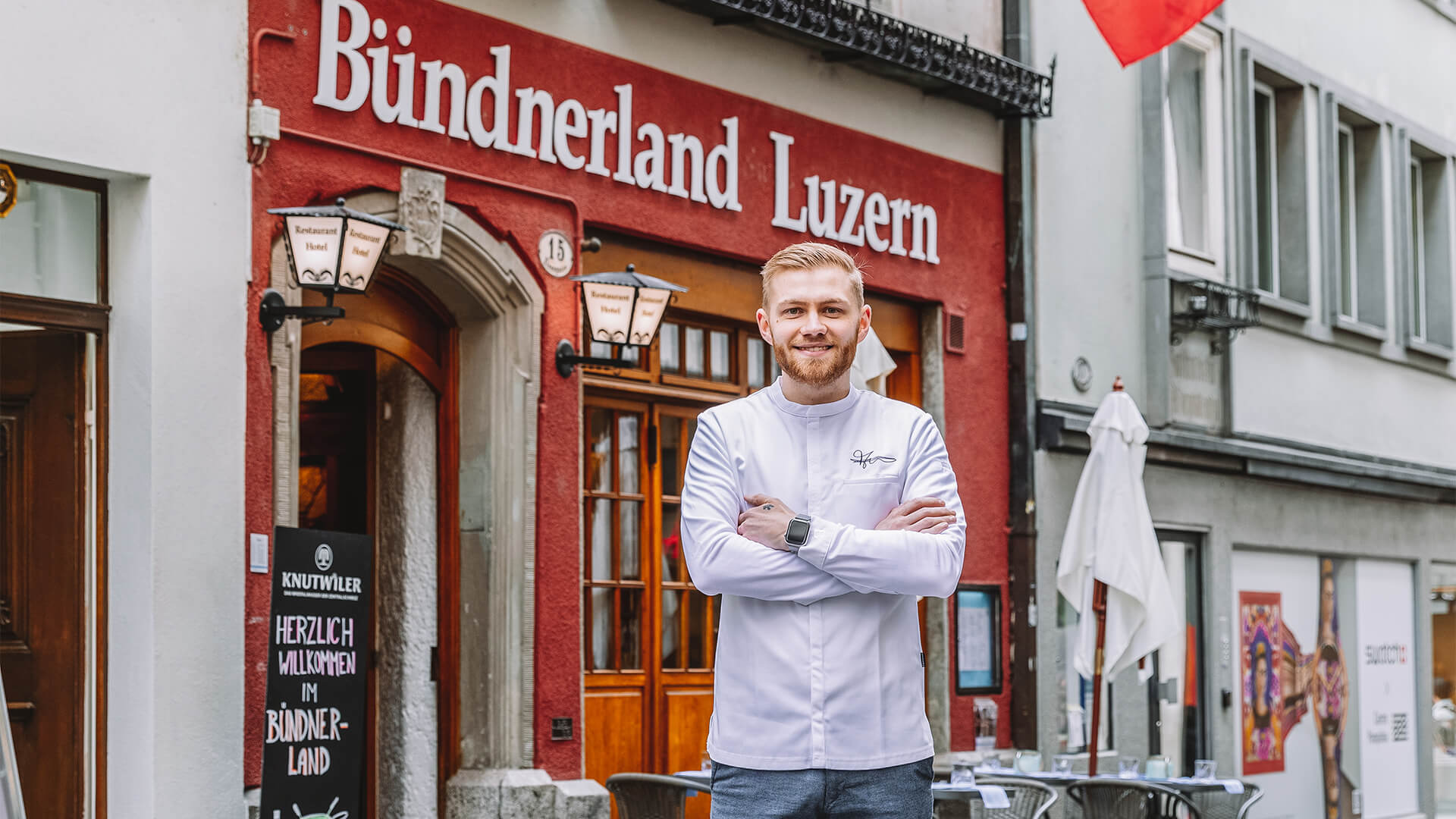 man standing in front of restaurant with arms crossed
