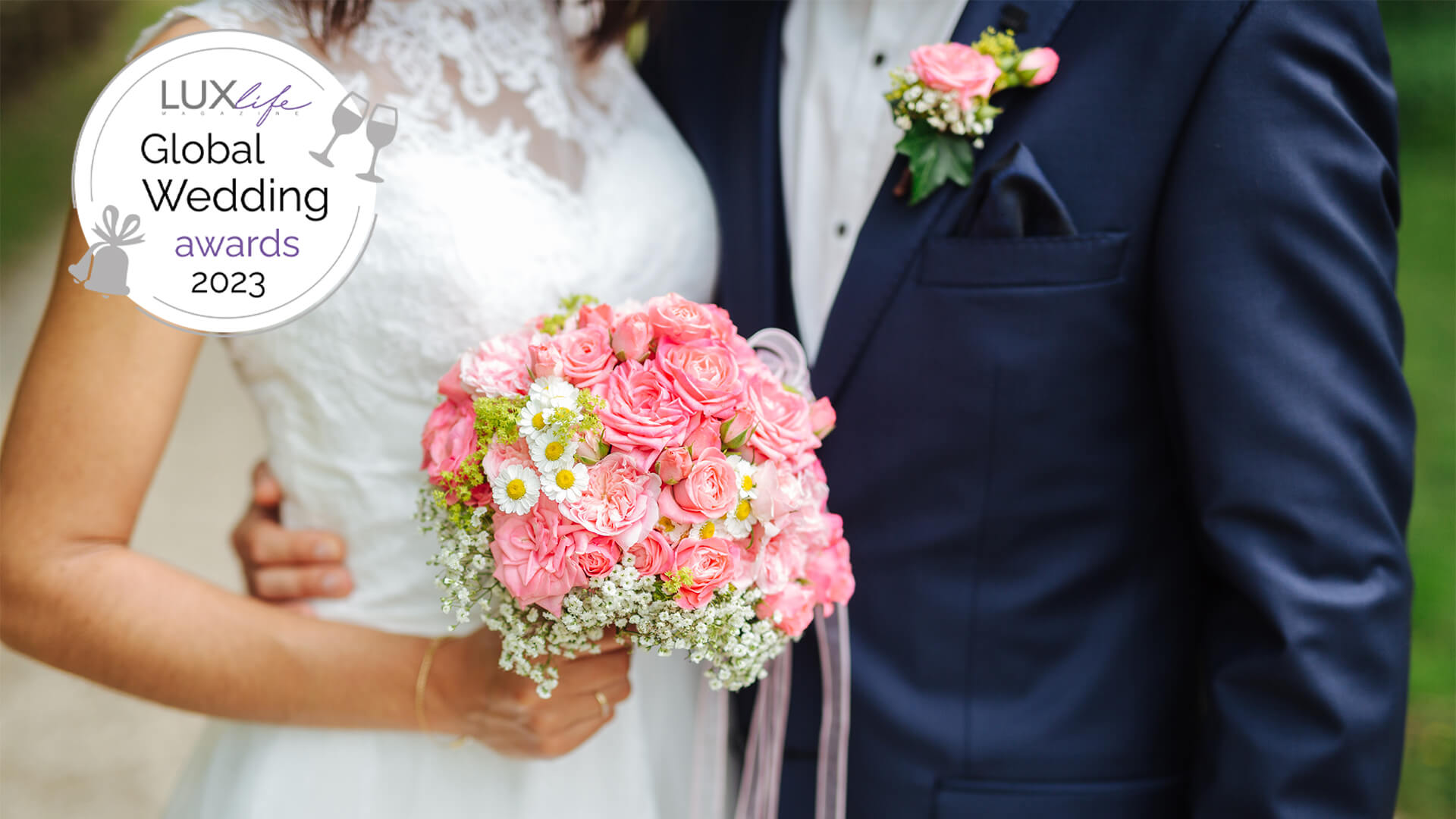 bride and groom standing together, the bride is holding a pink flower boquet