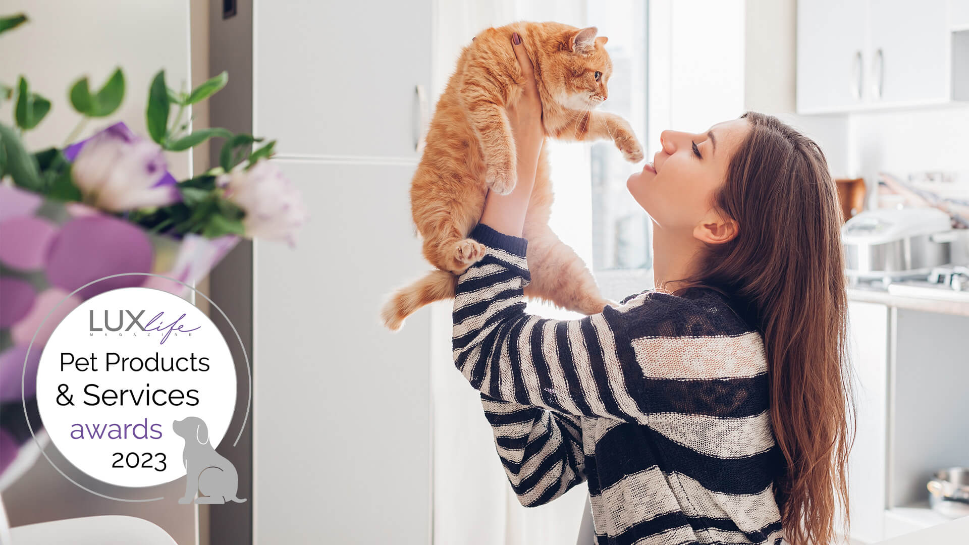 woman holding up cat in air